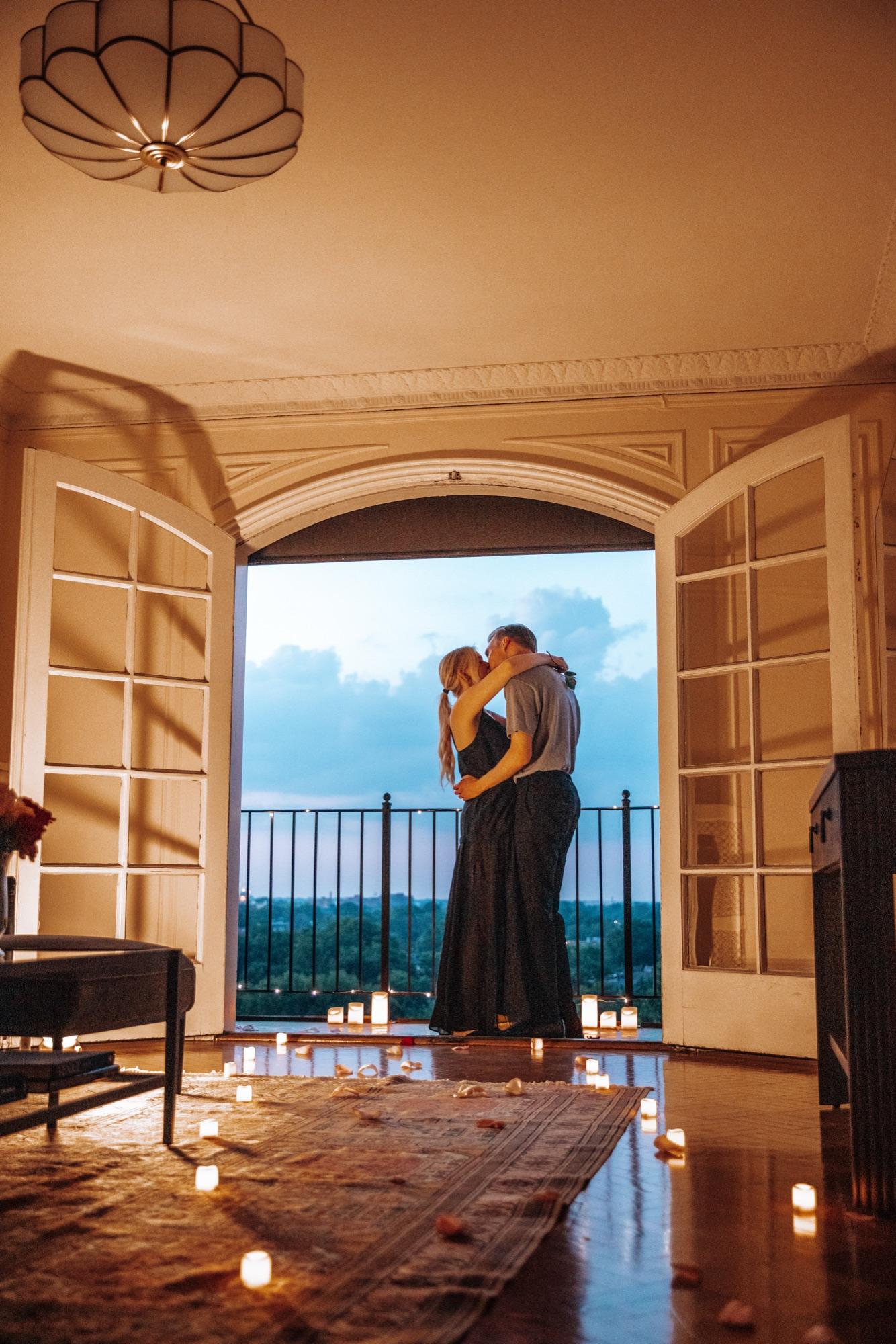 Couple kissing framed in a doorway against the evening sky