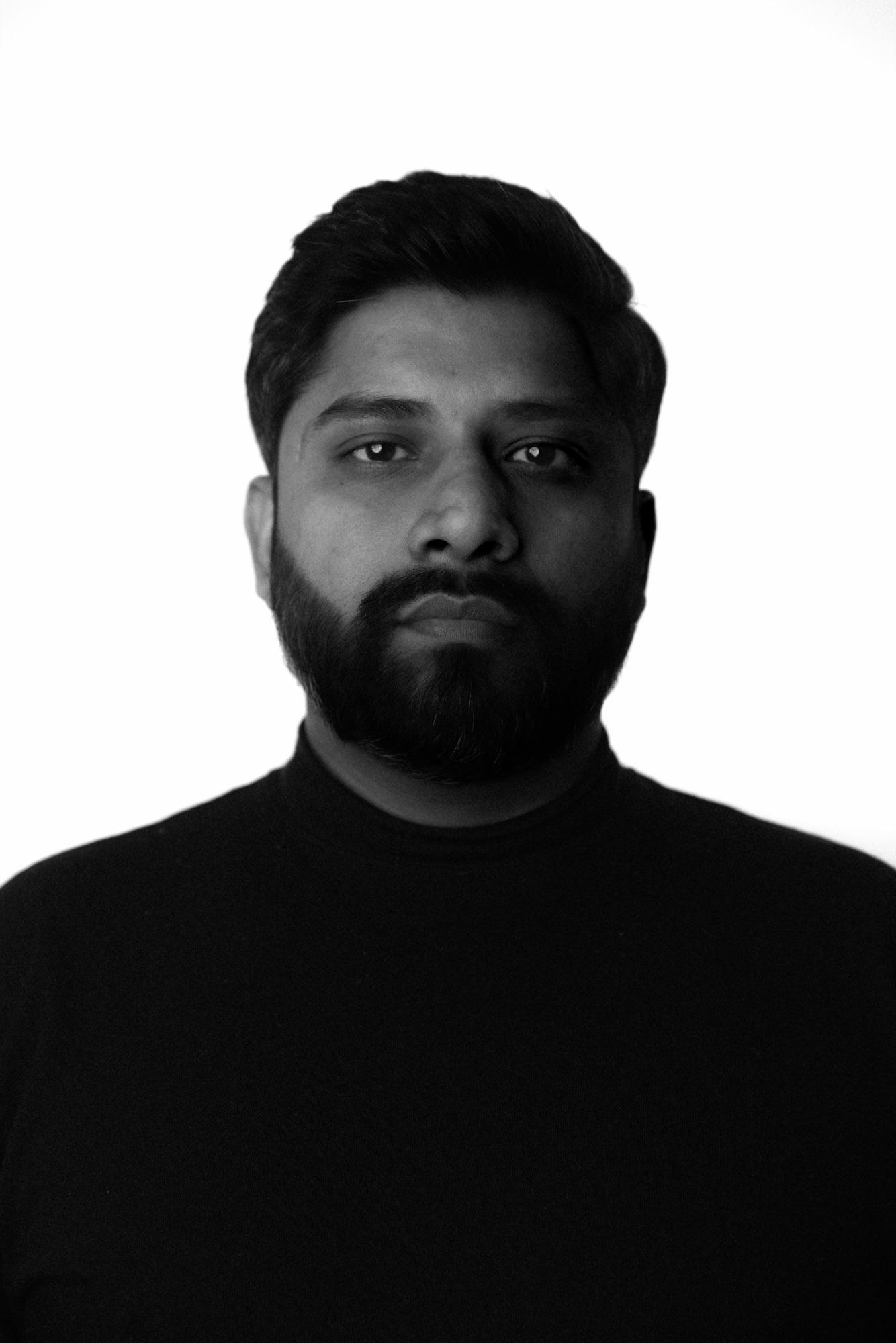 Low-key studio portrait, half-lit against black