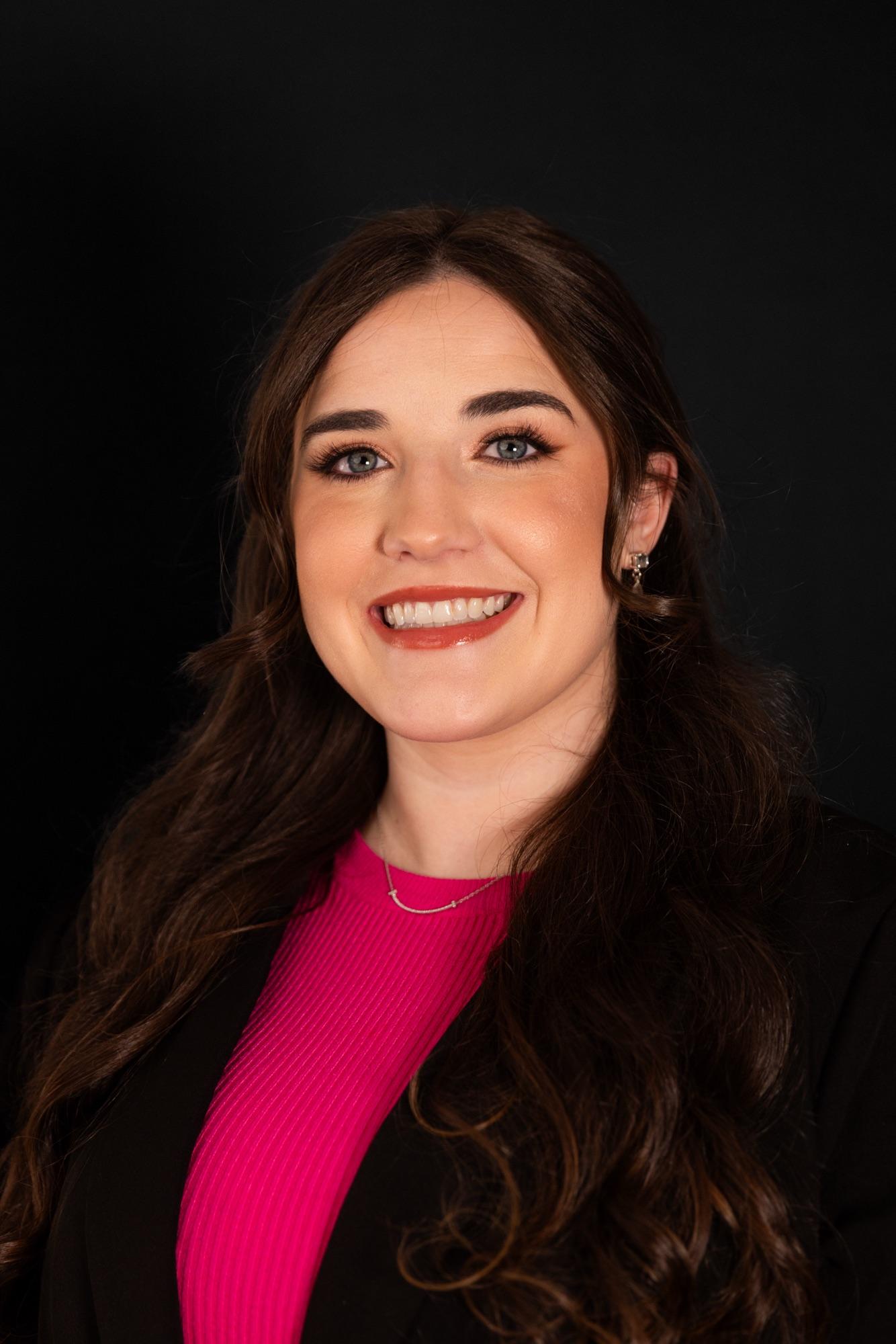 Studio portrait on black — glossy curls and a wide smile