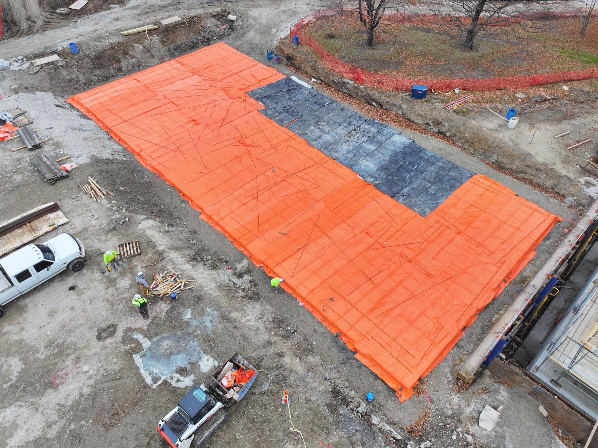 Winter concrete curing blankets in construction orange, crew at work — Steinberg project documentation