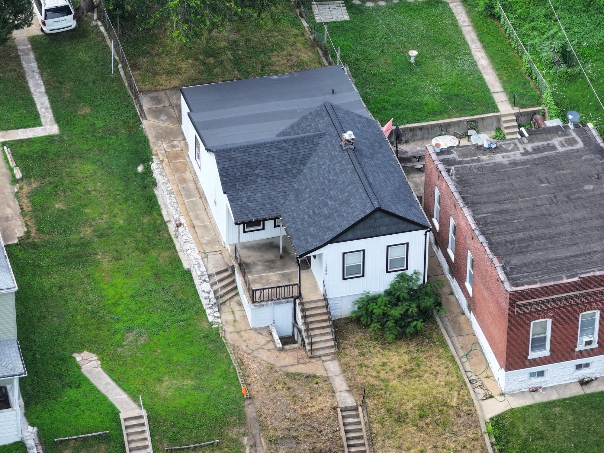 Top-down aerial of a residential listing and its neighboring rooftops