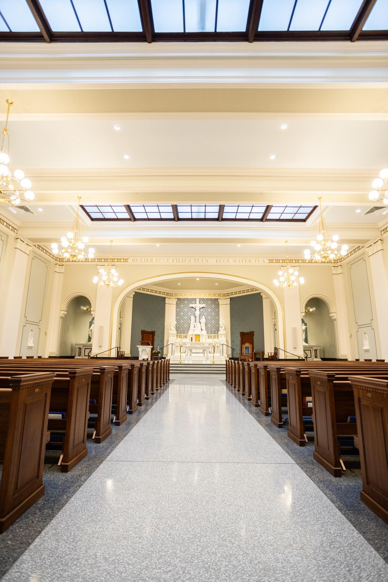 Restored SLUH chapel interior — pews, skylight, and altar in natural light