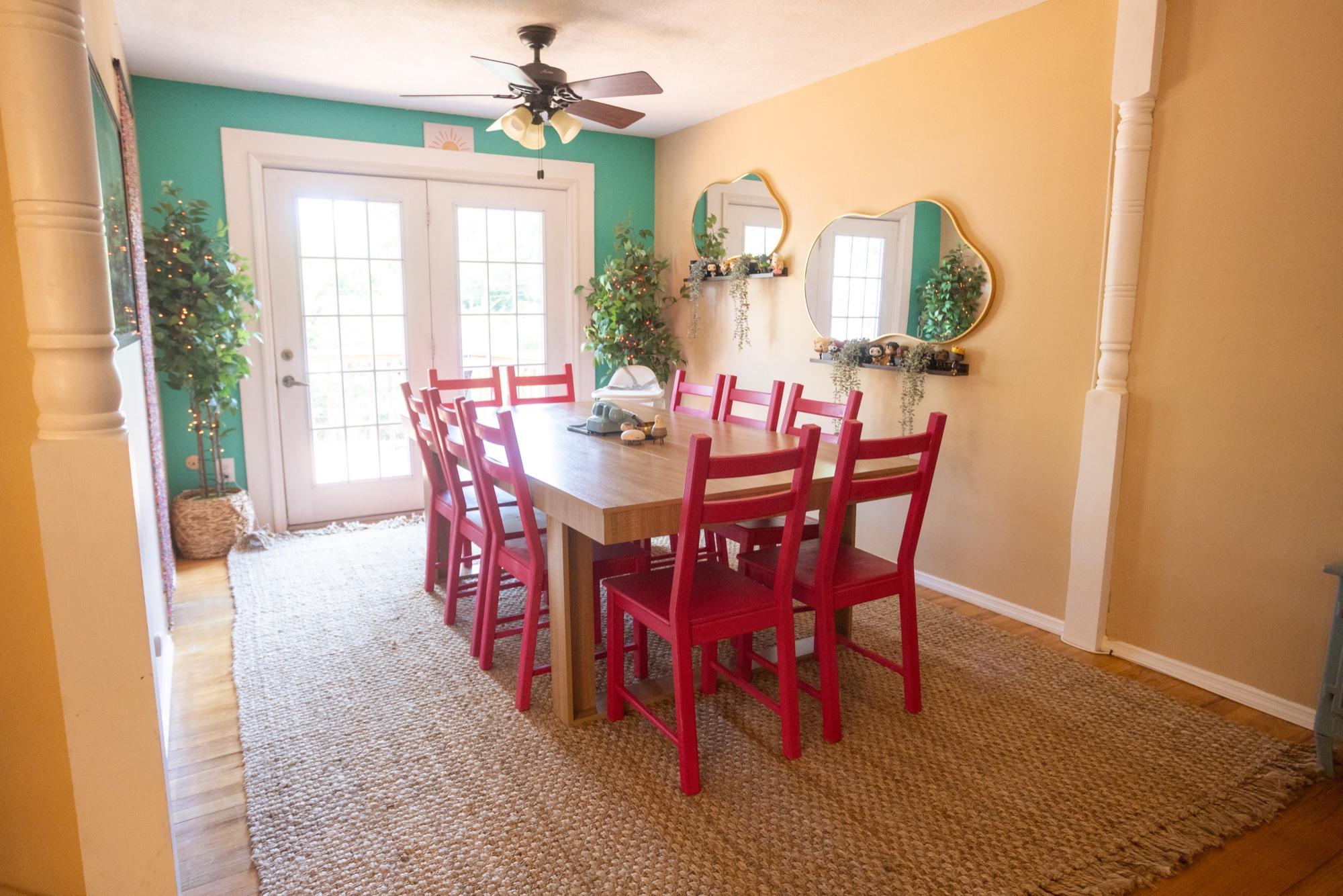 Short-term-rental dining room in warm light with red chairs