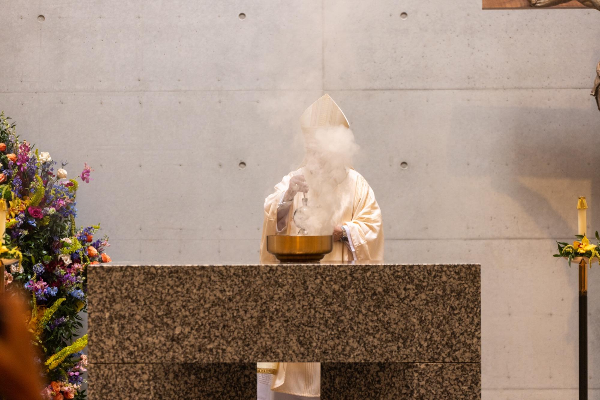 Incense rising over the granite altar during the consecration Mass of a newly built chapel
