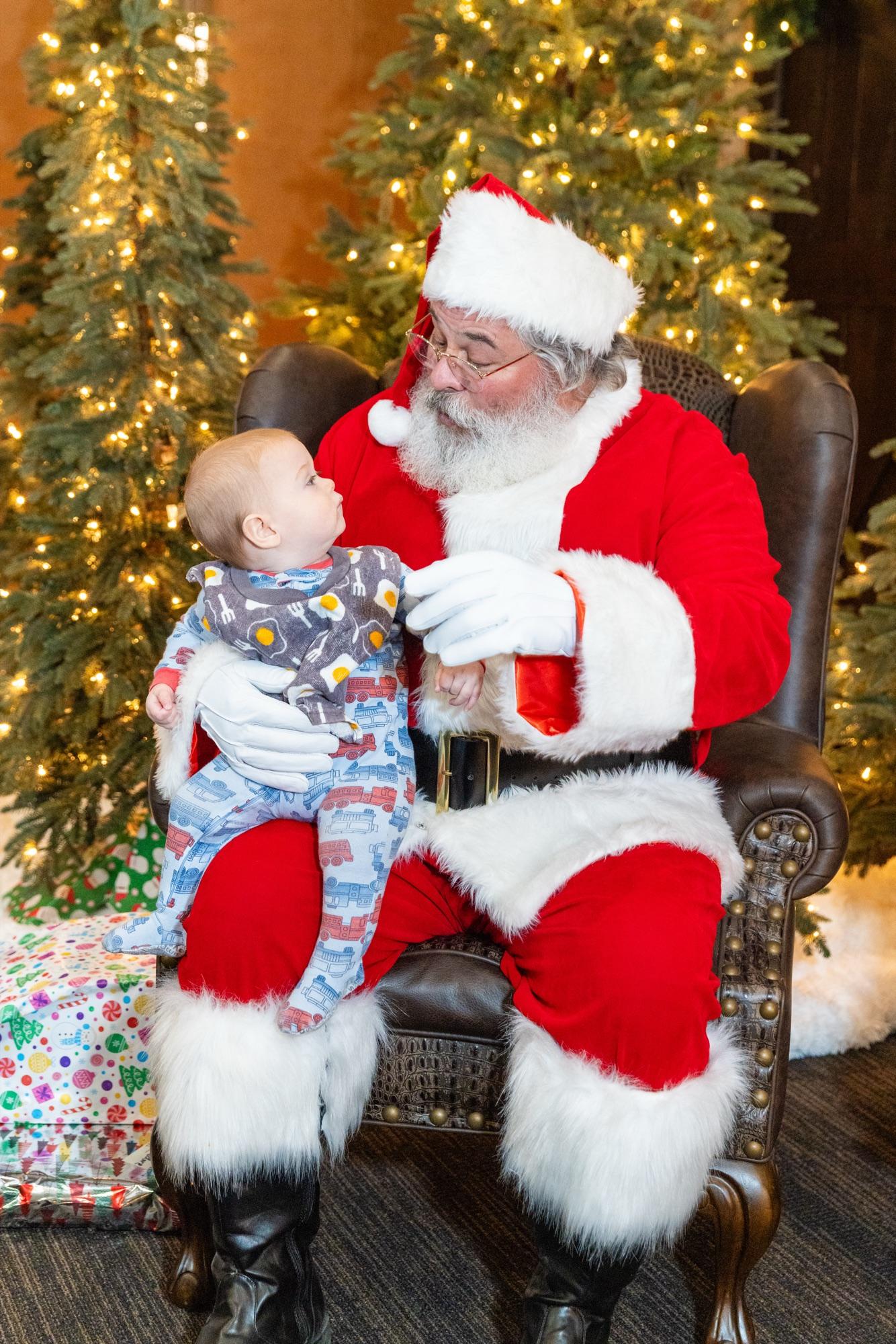 Baby looking up at Santa mid-session